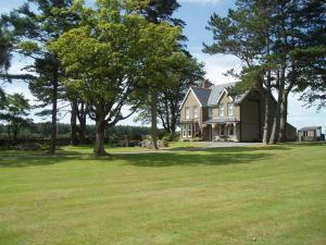 uma casa grande com árvores no quintal em Gwrach Ynys Country Guest House em Harlech