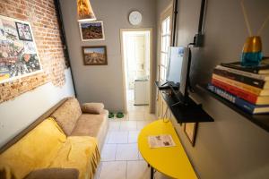 ein Wohnzimmer mit einem gelben Sofa und einem gelben Tisch in der Unterkunft Apartamento no centro com estacionamento in Santa Maria