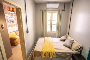 Kleines Zimmer mit einem Bett und einem Fenster in der Unterkunft Apartamento no centro com estacionamento in Santa Maria