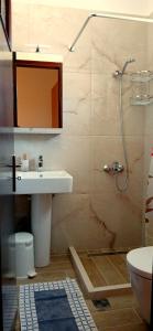 La salle de bains est pourvue d'un lavabo et d'une douche. dans l'établissement Filippos Apartments "Apartment 2", à Spartià