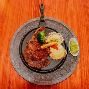 een bord met vlees en groenten op tafel bij Hotel Glamping & Restaurant Fuerza Ancestral in Tlalmanalco de Velázquez