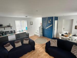 a living room with a blue door and a kitchen at Tankerton Beach Daze in Kent