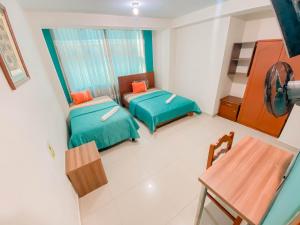 Habitación pequeña con 2 camas y mesa. en Hotel Señor de Sipán, en Chiclayo