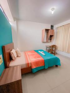 Dormitorio pequeño con cama y mesa en Hotel Señor de Sipán en Chiclayo