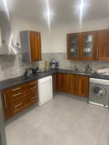 a kitchen with wooden cabinets and a washer and dryer at 2 Bed Apartment in Gibraltar - Marina Views in Gibraltar