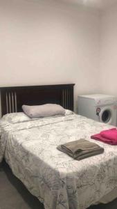 ein Schlafzimmer mit einem Bett mit einer Decke und einer Mikrowelle in der Unterkunft 2 Bed Apartment in Gibraltar - Marina Views in Gibraltar