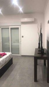 a bedroom with a bed and a table and a door at 2 Bed Apartment in Gibraltar - Marina Views in Gibraltar