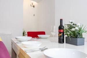 - une table avec des bols blancs et une bouteille de vin dans l'établissement Manor Terrace Retreat, à Accrington