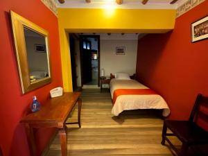 a bedroom with a bed and a mirror and a table at Casa Bonita Colonial in Cajamarca