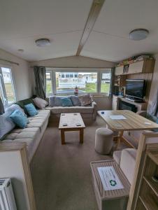 a living room with a couch and a table at D11 - the Dunes at Silver Sands in Lossiemouth