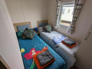 two beds in a small room with a mermaid on them at D11 - the Dunes at Silver Sands in Lossiemouth