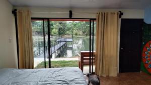 1 dormitorio con cama y vistas al río en Persea Inn Finca Integral Sostenible Organica Toro Careto, en Copey