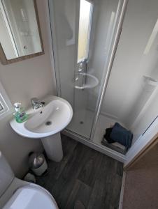 a bathroom with a shower and a sink and a toilet at D11 - the Dunes at Silver Sands in Lossiemouth
