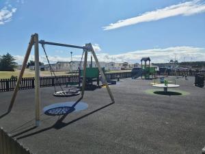 a group of swings in a playground at D11 - the Dunes at Silver Sands in Lossiemouth