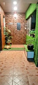 a lobby with a green wall and a plant at Zoey's Hill View in Navi Mumbai