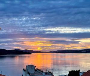 una gran masa de agua con una puesta de sol en el fondo en Penthouse Apartment LUX with a panoramic view, located on the beachfront of Ciovo-Trogir, en Trogir