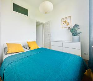 sypialnia z niebieskim łóżkiem z żółtymi poduszkami w obiekcie Green&Comfy Apartment Żoliborz w Warszawie