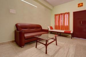 sala de estar con sofá de cuero y mesa en OYO Hotel Radhakrishna, en Madurai