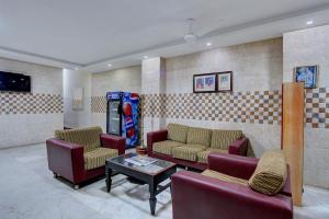 una sala de espera con sofás y una mesa en una habitación en OYO Hotel Radhakrishna, en Madurai