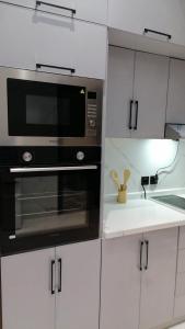 a kitchen with a black microwave and white cabinets at شاليهات السلطان 3 غرف قريبه من الحرم بحي الملك فهد in Sīdī Ḩamzah