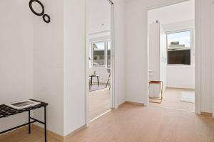 Habitación blanca con mesa y espejo. en New! Modern & Central Couples Apartement! en Bergen