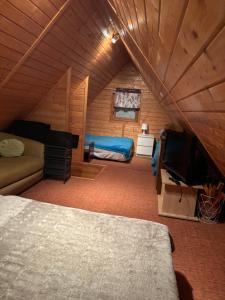 ein Schlafzimmer mit einem Bett und einem TV in einem Zimmer in der Unterkunft Domek w Górkach in Górki Wielkie