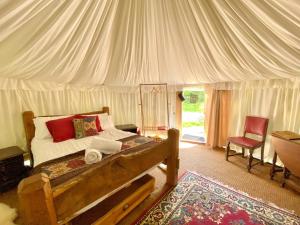 a bedroom with a bed in a tent at Elessar Yurt Village in Chichester