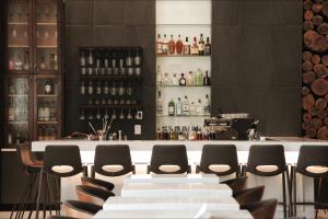 een bar met stoelen en een bar met wijnflessen bij TRYP by Wyndham Savannah in Savannah