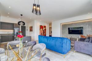 sala de estar con sofá azul y sillas en Luxurious & Peaceful Sandton 3-bed - Backup Power, en Johannesburgo