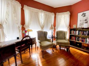 a room with a desk and two chairs and a piano at Magnolia House Inn in Hampton