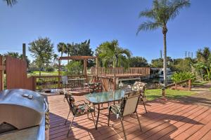 a patio with a table and chairs on a deck at Colorful Canalfront Merritt Island Home Gas Grill in Merritt Island