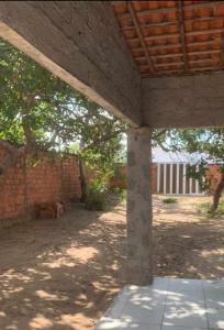 an outdoor patio with a brick wall and a wooden roof at Casa temp. barreirinhas in Barreirinhas
