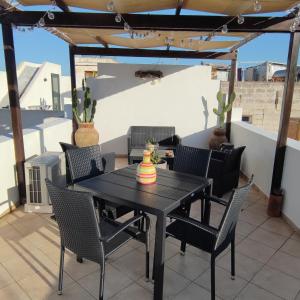 - une table et des chaises noires sur la terrasse dans l'établissement Saline, à Favignana