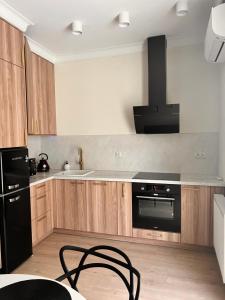 a kitchen with wooden cabinets and a black appliance at Apartament Old Town Bednarska 22 in Elblag