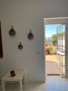 una puerta abierta a un patio con mesa en Posidonia, en Milazzo