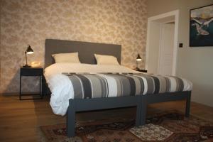 a bedroom with a bed with a black and white comforter at Château La Fontaine - stylish accomodation - green environment in Mons
