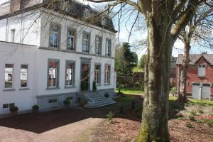 a white house with a tree in front of it at Château La Fontaine - stylish accomodation - green environment in Mons