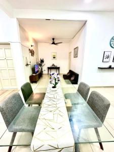 un comedor con una mesa larga y sillas en The Amore Homestay Klebang, Melaka, en Melaka