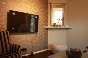 sala de estar con TV de pantalla plana en la pared en Château La Fontaine - stylish accomodation - green environment, en Mons