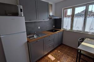 a kitchen with a white refrigerator and a sink at Altana Rooms Apartment in Koper