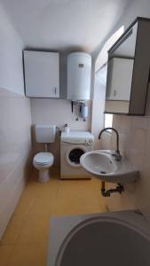 a small bathroom with a toilet and a sink at Altana Rooms Apartment in Koper