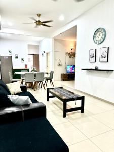 uma sala de estar com um sofá e uma mesa em The Amore Homestay Klebang, Melaka em Malaca
