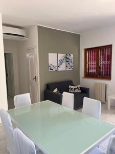 sala de estar con mesa y sillas blancas en Posidonia, en Milazzo