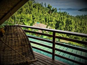 a hammock hanging from a balcony overlooking a river at The Overlook in San Vicente