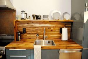 Trendy Studio in Prime South Philly Neighborhood في فيلادلفيا: مطبخ مع حوض وأعلى كونتر خشبي