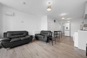 a living room with black leather furniture and a table at Stylish 3Bedroom House in Prime Leicester Location in Humberstone