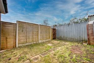 a wooden fence in a yard next to a fence at Stylish 3Bedroom House in Prime Leicester Location in Humberstone