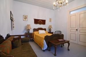 Phaos Chios في Vrontádos: غرفة نوم بسرير واريكة