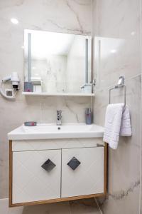 a bathroom with a sink and a mirror at Cihan Bey Otel Belek in Belek