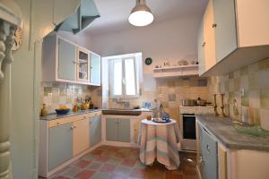 a kitchen with white cabinets and a table in it at Phaos Chios in Vrontados